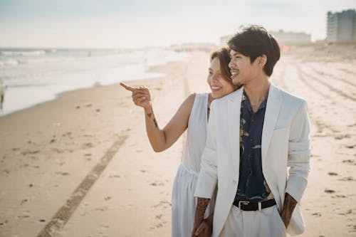 Couple in White Clothes Walking at the Beach