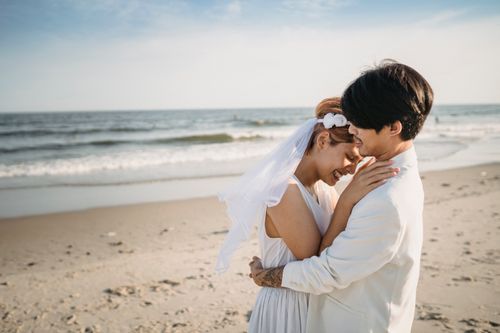 Free Bride and groom embracing on a picturesque beach, celebrating love and romance. Stock Photo