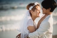 Newlyweds embracing on the beach