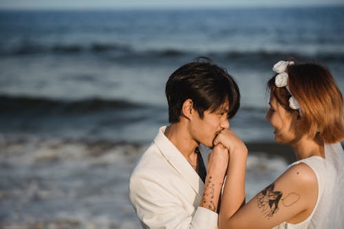 Free Man Kissing Woman's Hand at the Beach Stock Photo