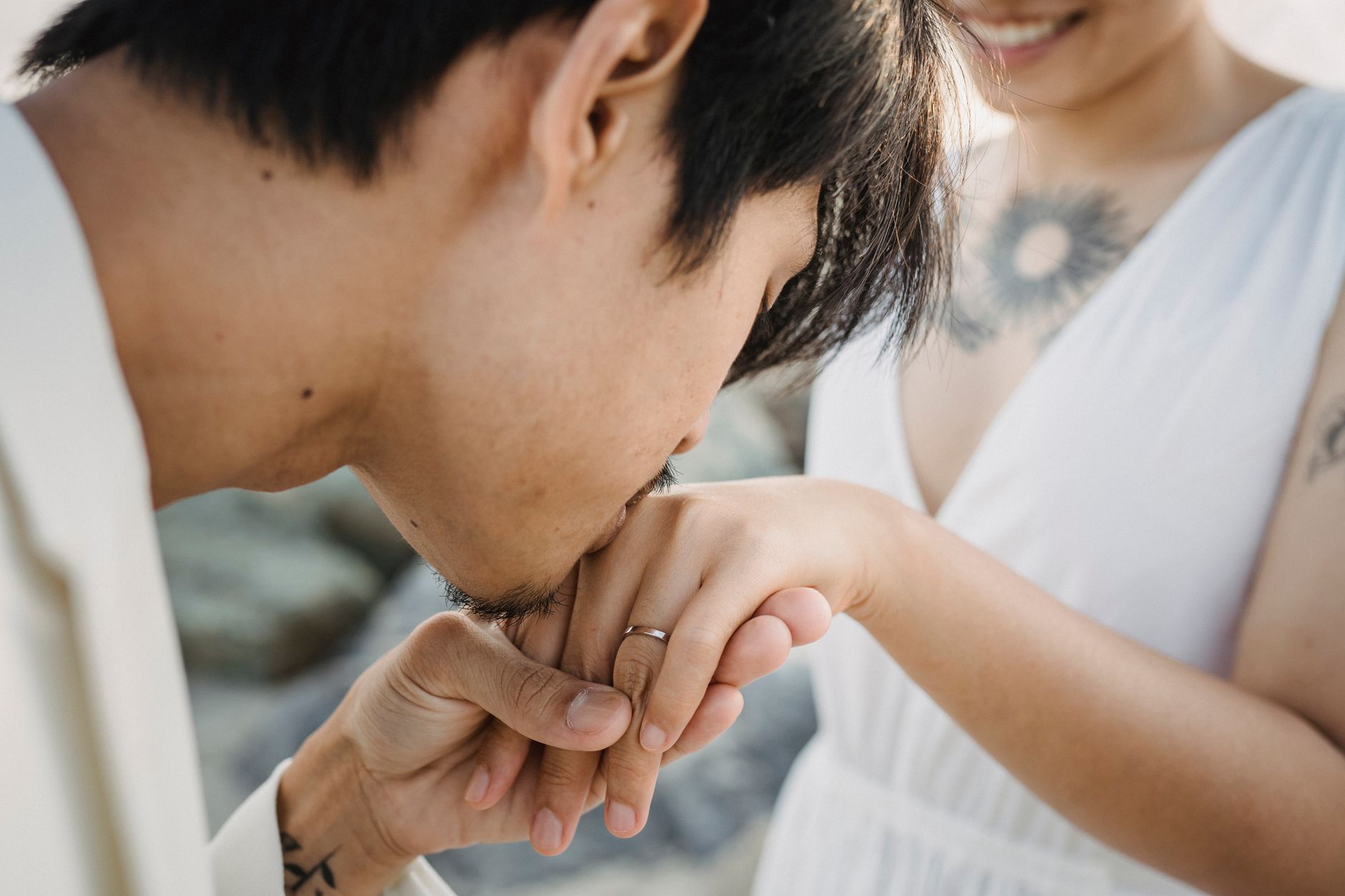 A romantic moment captured as a man kisses a woman's hand, symbolizing love and affection.