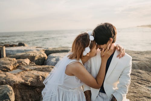 Free Woman in White Dress Touching Man's Face Stock Photo