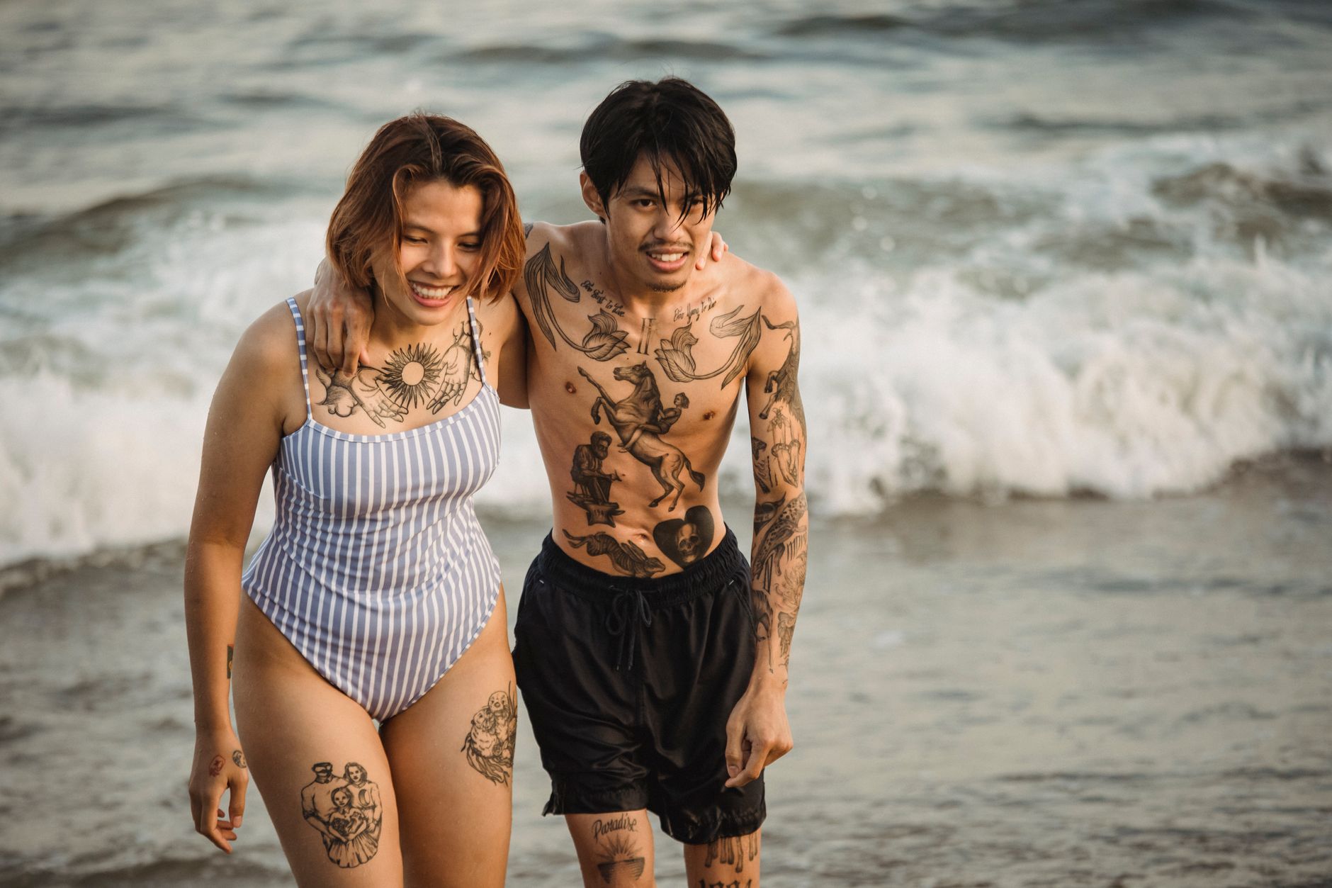 Couple portant des tatouages temporaires à la plage, ambiance décontractée et lifestyle jeune
