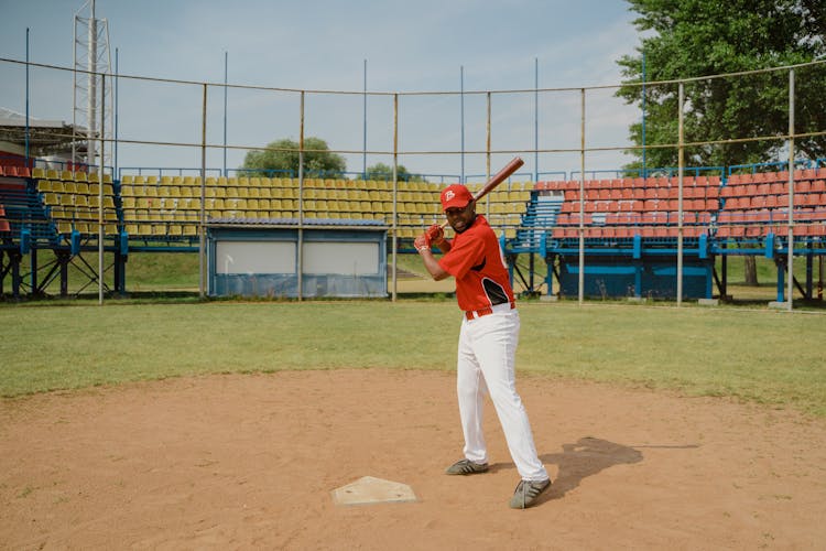 Man In Red Shirt And White Pants Playing Baseball