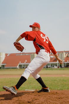 Dynamic action shot of a baseball player pitching during a sunny day game.
