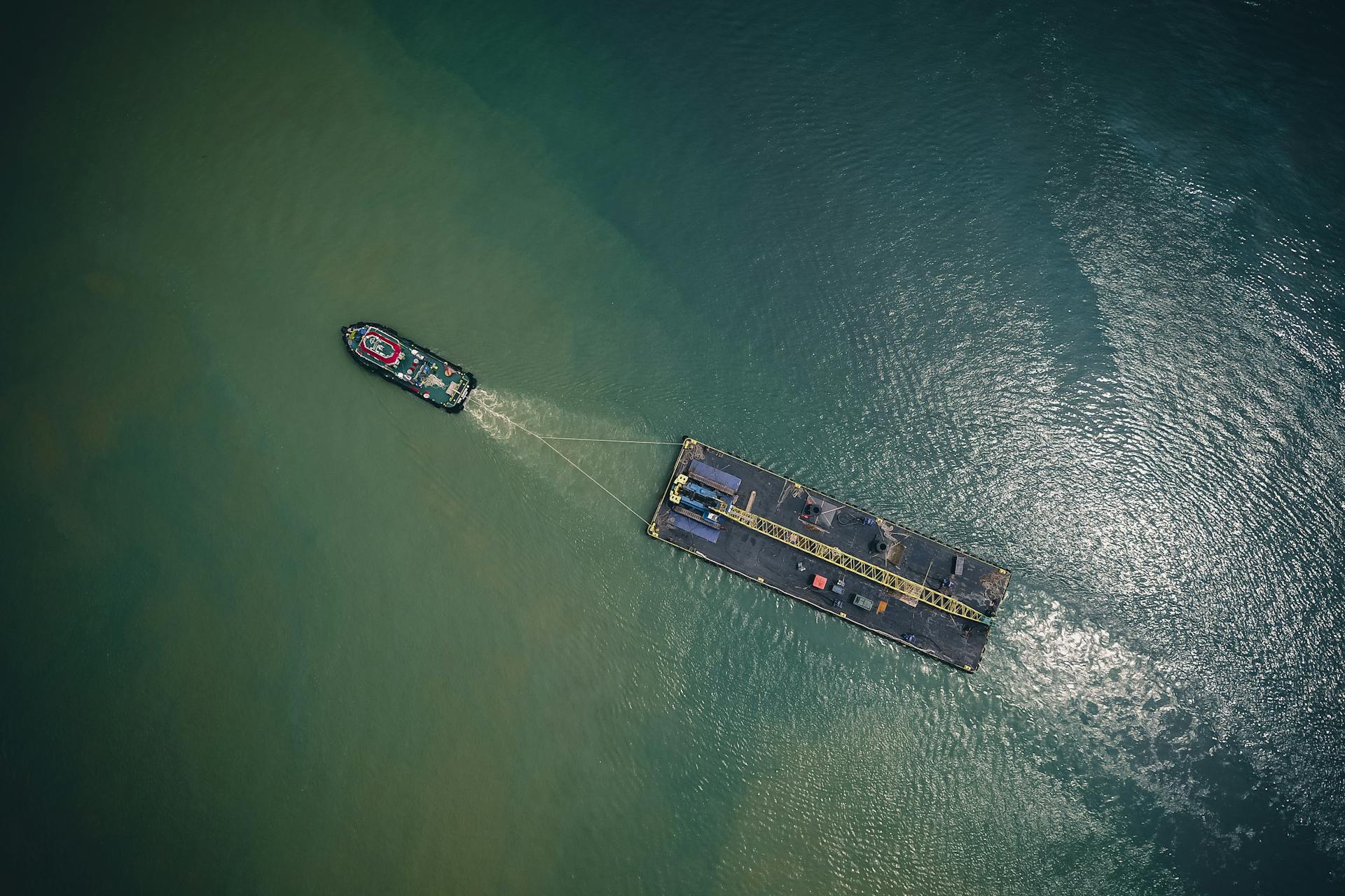 High angle of modern vessel with cargo trailer floating on rippling water of sea in sunny day