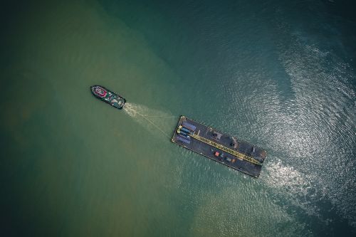 Free High angle of modern vessel with cargo trailer floating on rippling water of sea in sunny day Stock Photo