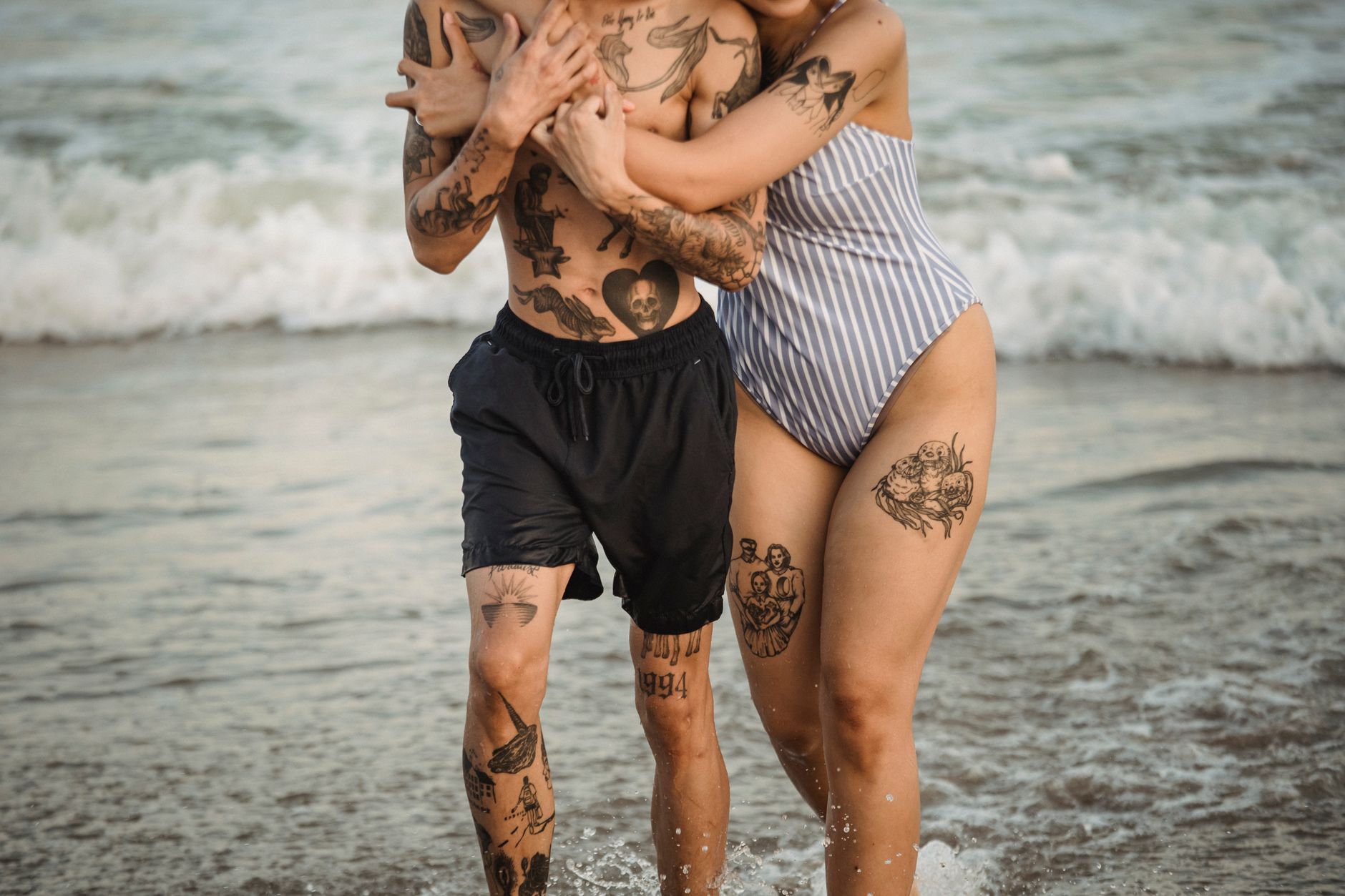 Couple enjoying beach lifestyle with visible rose temporary tattoos on their skin