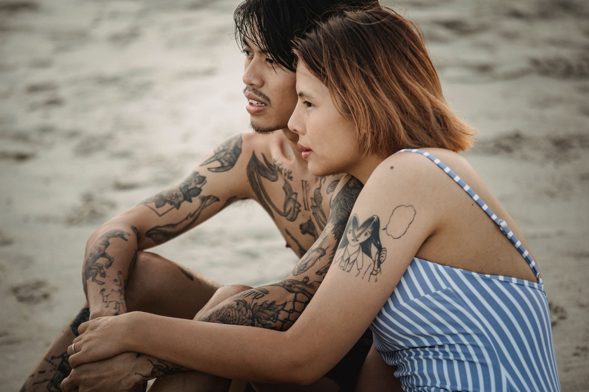 Couple lifestyle portant des tatouages géométriques temporaires visibles InkToday en sortie