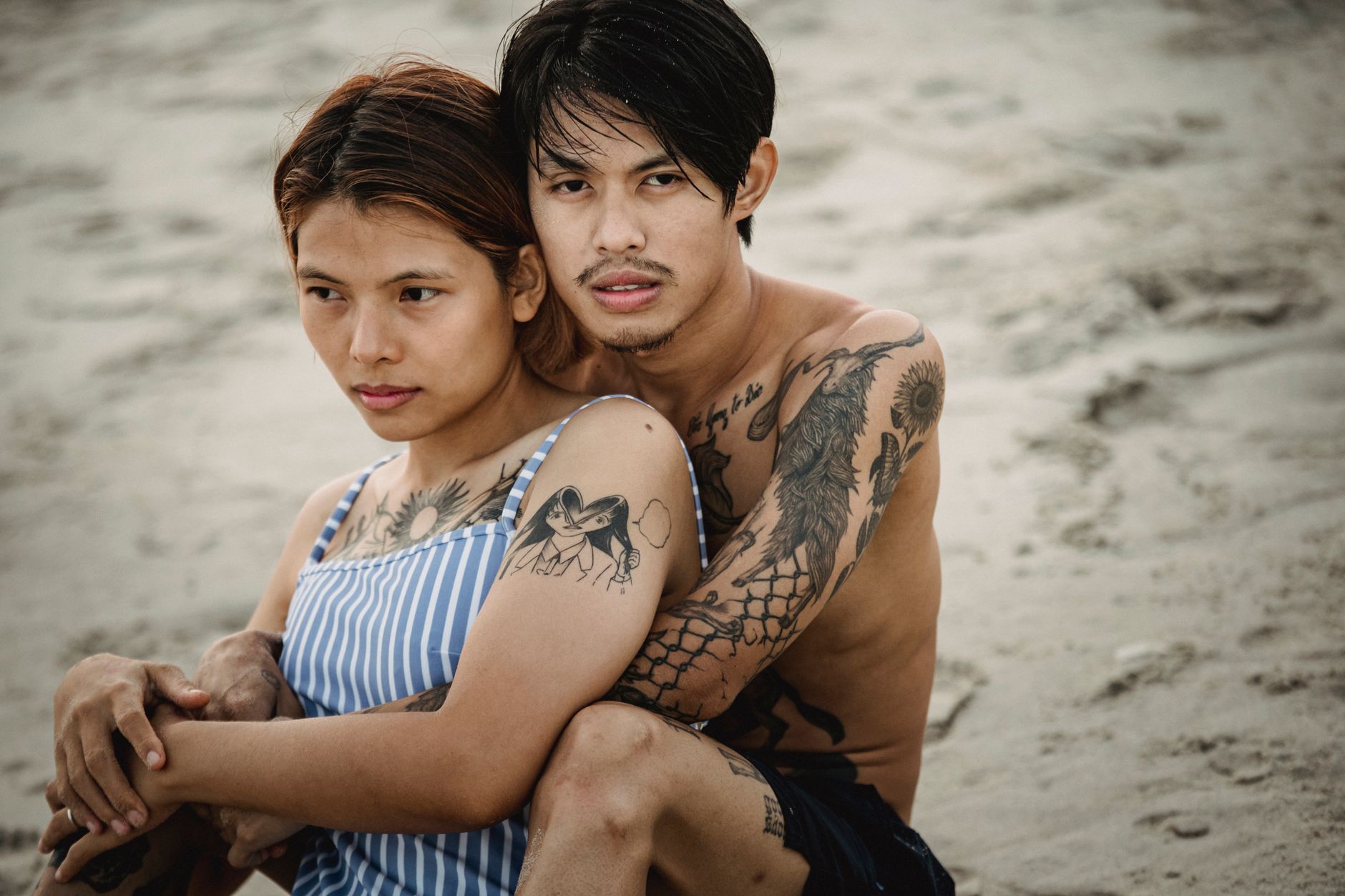 Couple portant des tatouages temporaires amour et bisou, ambiance plage et insouciance