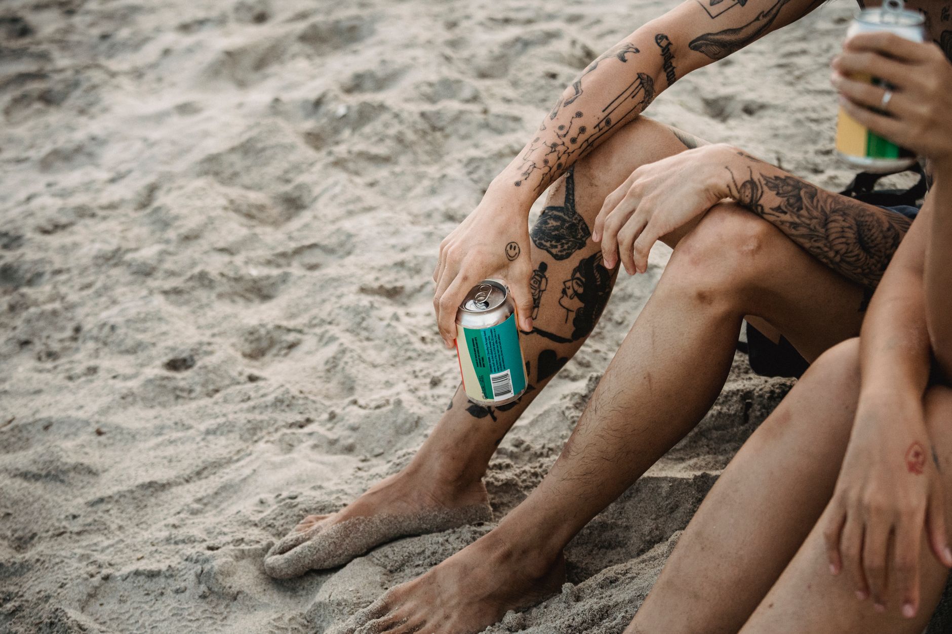 Group of friends at beach displaying moon temporary tattoos on shoulders and arms together