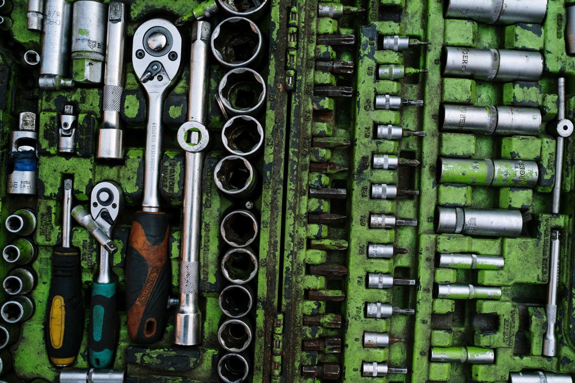 An organized workshop toolbox containing ratchets and hand tools