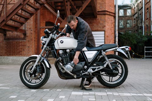 Man in Gray Jacket Riding on White and Black Motorcycle