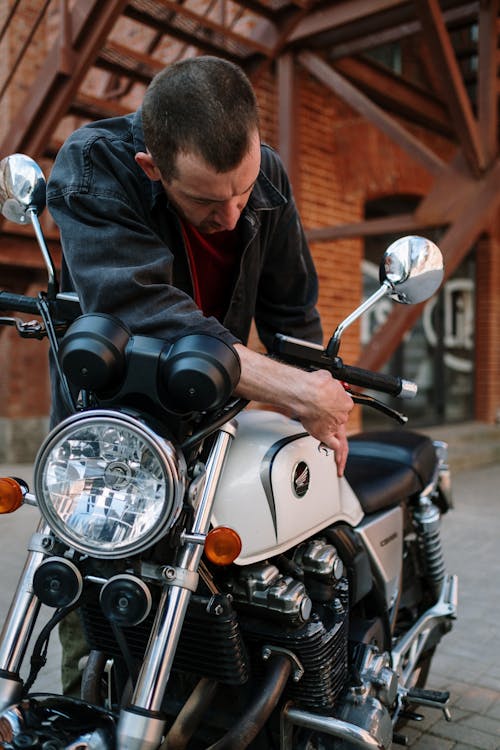 Man in Black Jacket Adjusting Side Mirrors on Motorcycle · Free Stock Photo