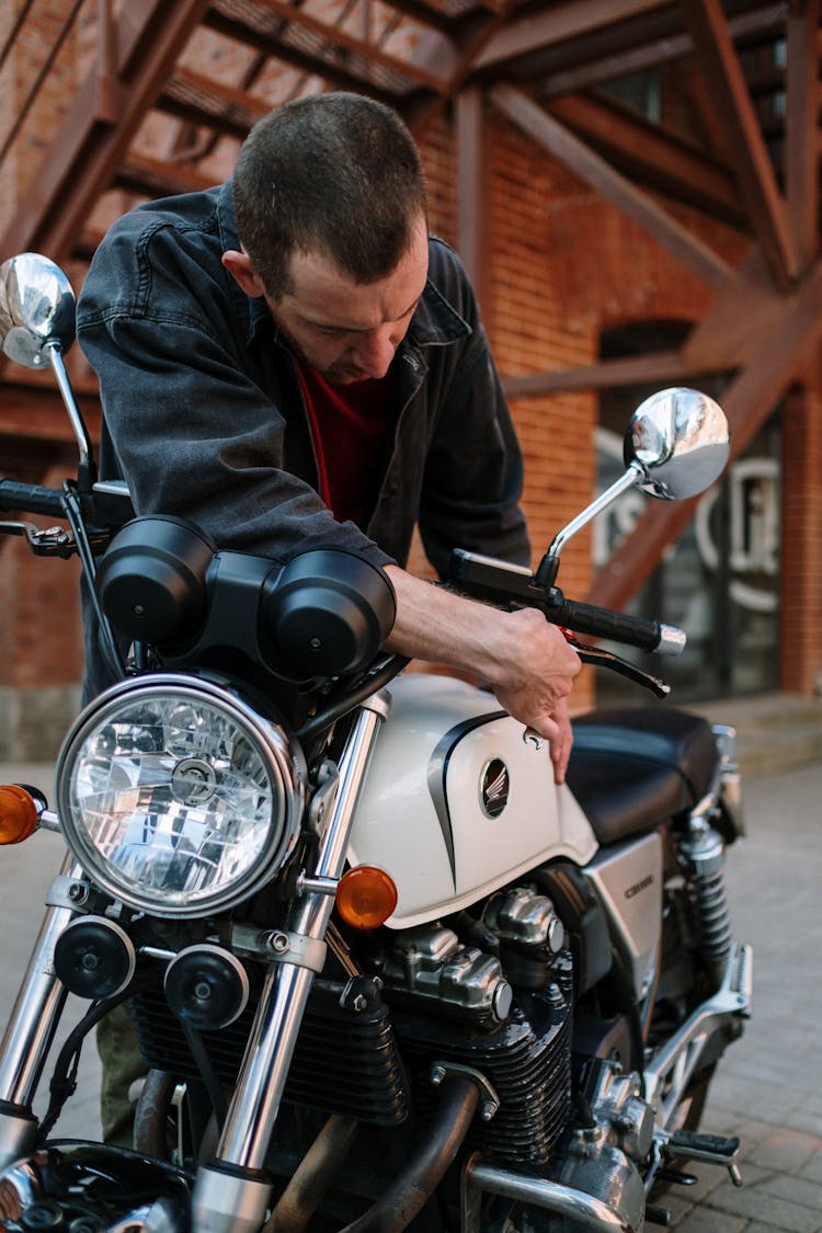 Man In Black Jacket Adjusting Side Mirrors On Motorcycle