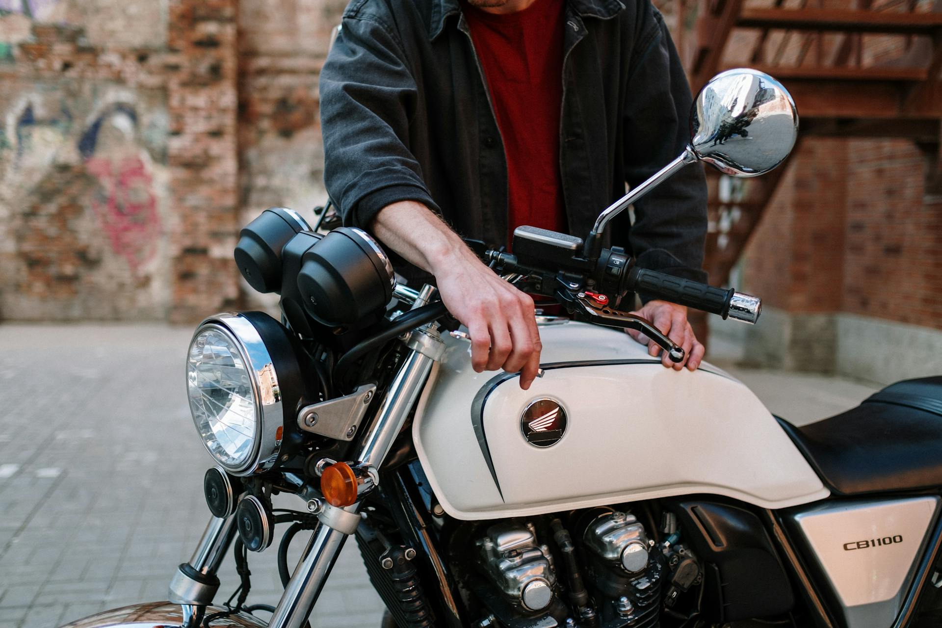 Man in Black Jacket Fixing Motorcycle