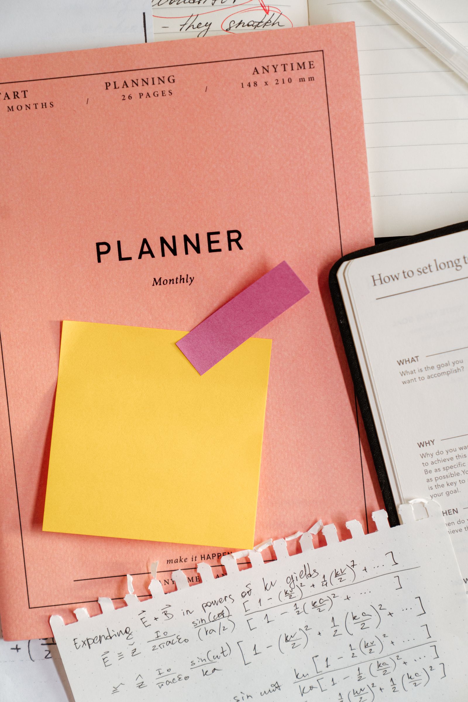 A planner with sticky notes used for a weekly knowledge review
