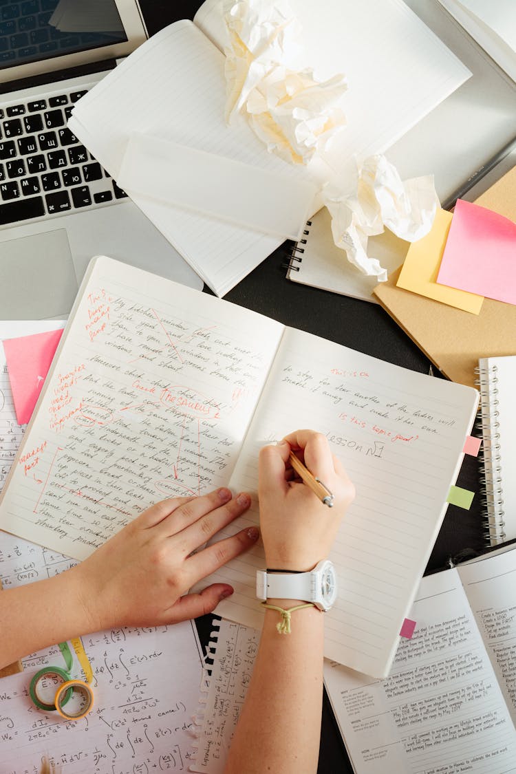 Person Writing On A Notebook