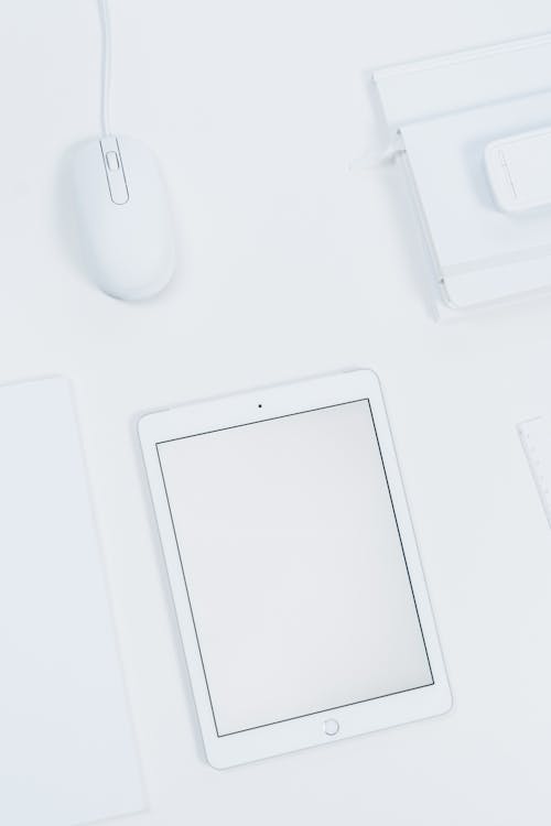 White Tablet and Mouse on a Table