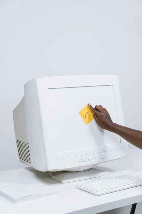 Free Putting a Sticky Note on a Computer Monitor Stock Photo