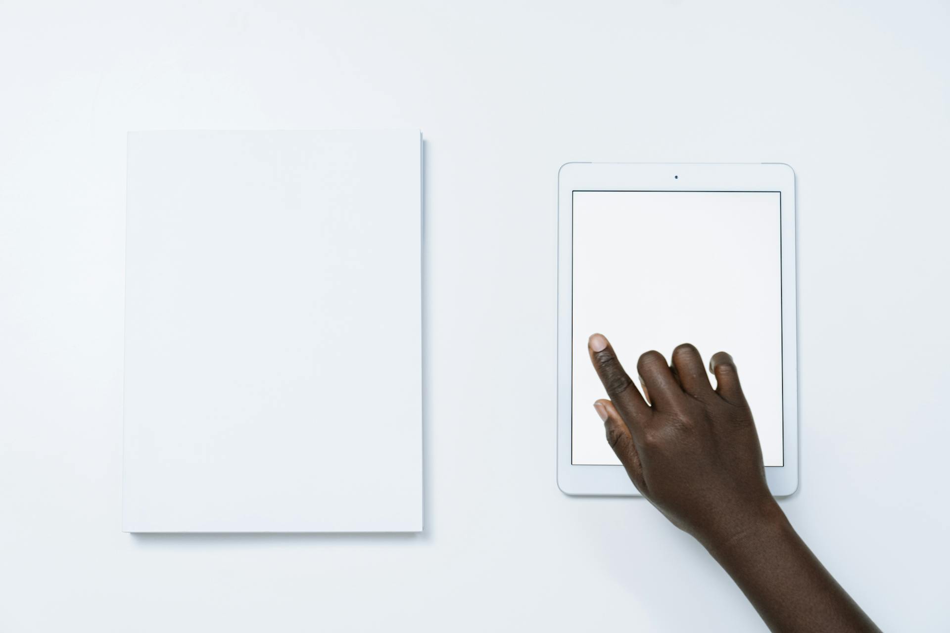 Pointing on a Screen of a Tablet Beside a Paper