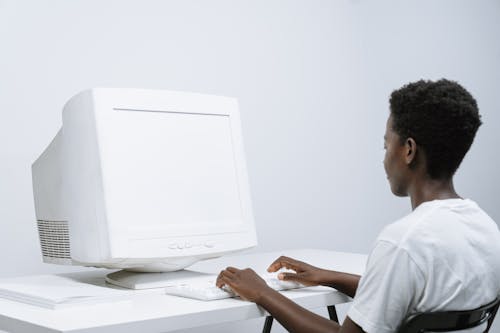 Free Person in White Crew Neck T Shirt Using a Computer Stock Photo