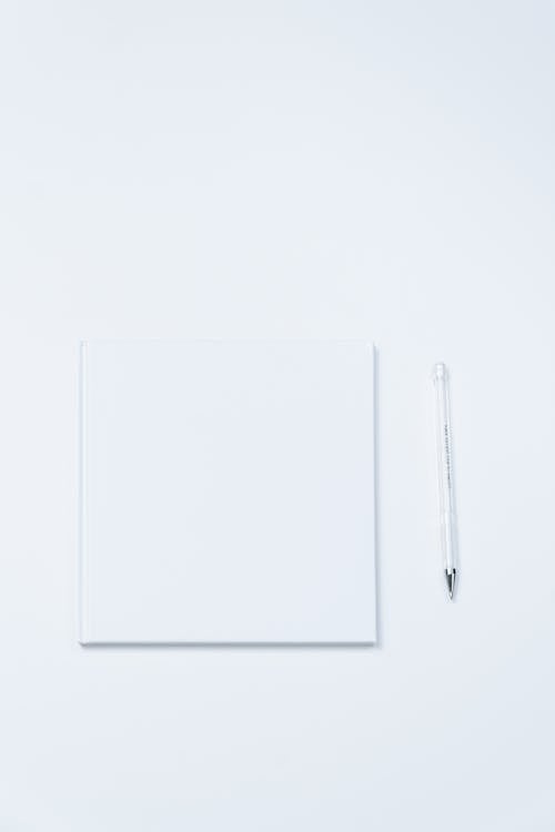 Paper and a Pen on a White Surface