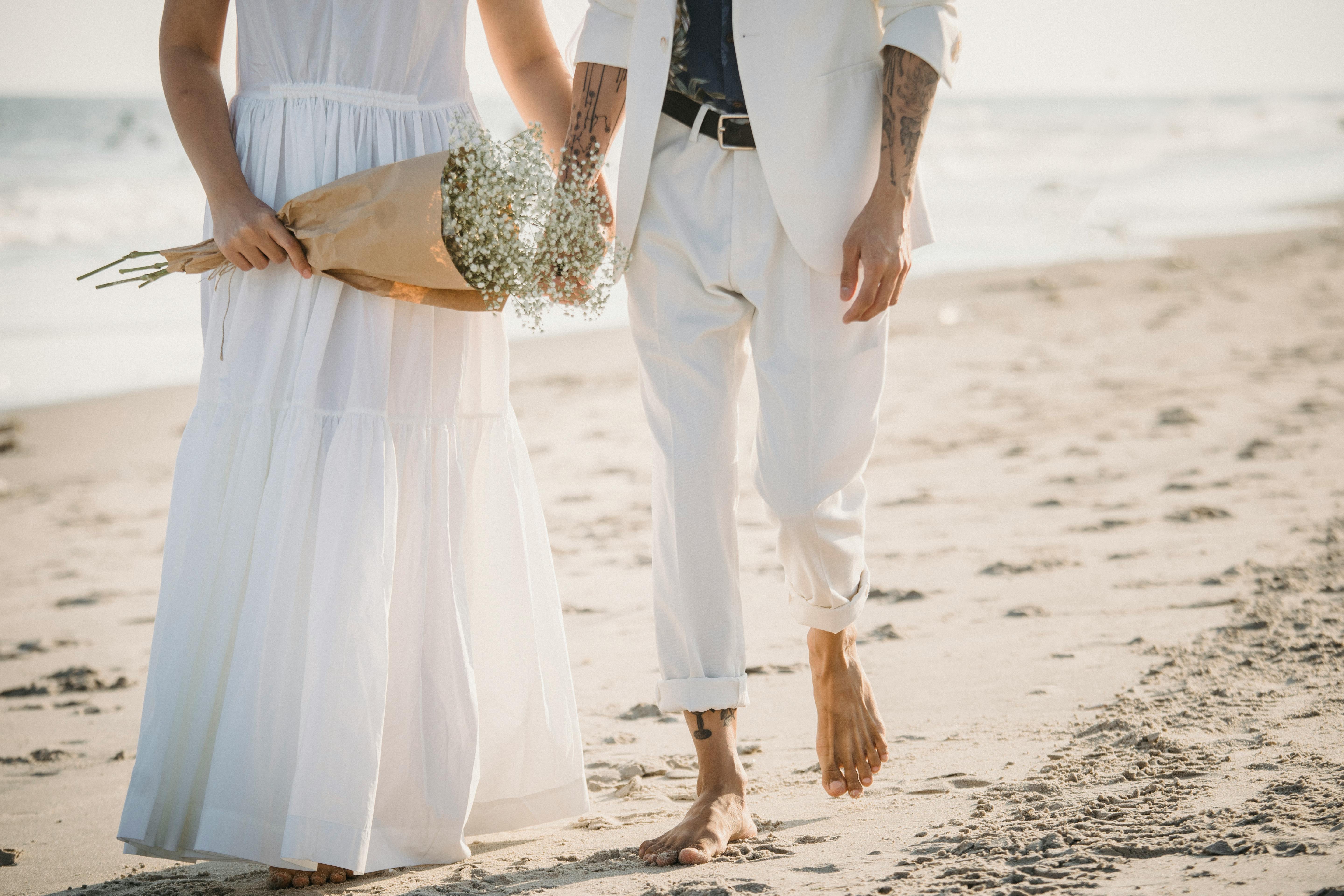 A Couple Walking Barefooted On The Beach · Free Stock Photo