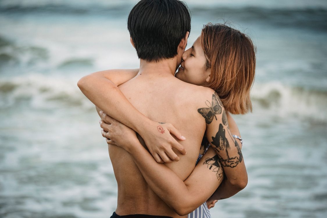 Man and Woman Hugging Near the Body of Water · Free Stock Photo