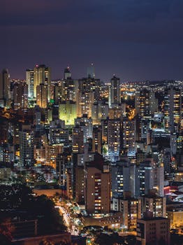 Vibrant nighttime cityscape of Belo Horizonte, Brazil, showcasing illuminated skyscrapers and urban lights.