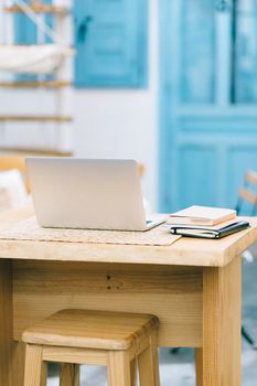 A serene home office setup with a laptop on a wooden desk, featuring natural lighting and a peaceful ambiance.