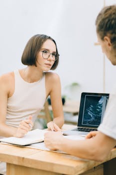 Two young professionals engaged in a collaborative workplace discussion.