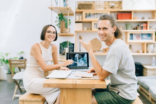 Man and Woman Sitting on Wooden Chairs