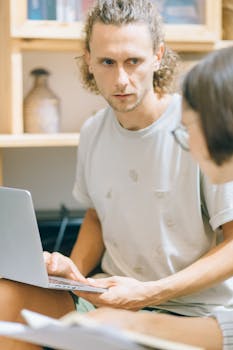 Two adults engaged in conversation, highlighting teamwork and collaboration in a casual workspace.