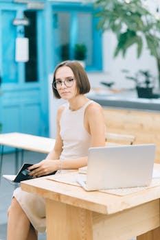 Woman sitting at a wooden desk in a stylish indoor workspace using a laptop.