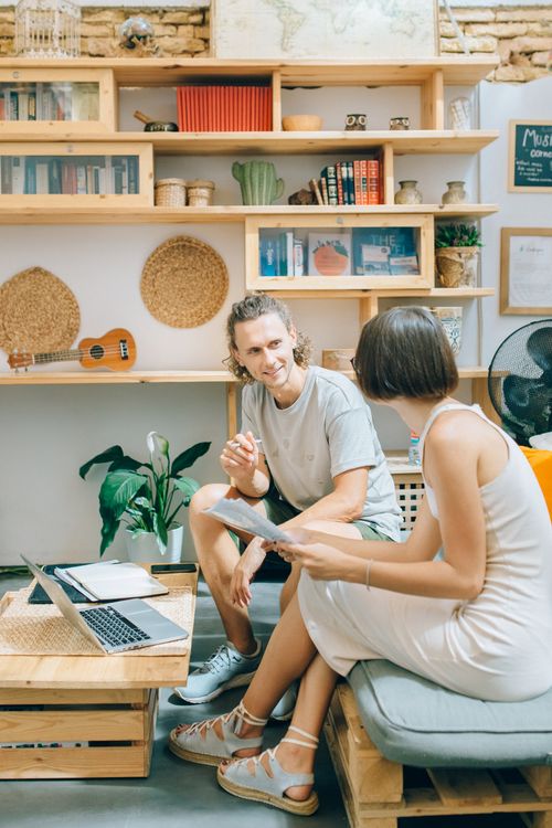 Free Two adults having a casual meeting in a cozy creative workspace. Stock Photo