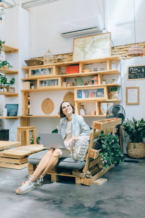 Free A woman in a casual setting working on a laptop in a beautifully decorated home office. Stock Photo