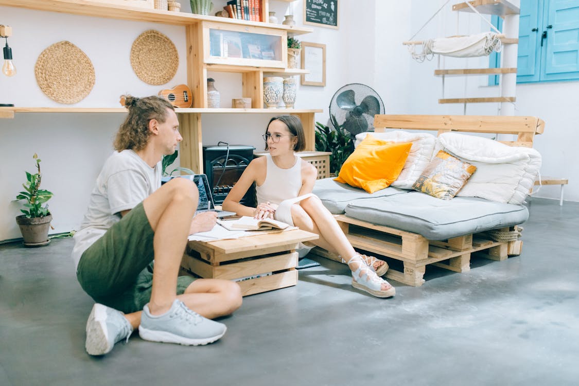 Free Woman in White Tank Top Sitting on Floor Beside Woman in White T-shirt Stock Photo