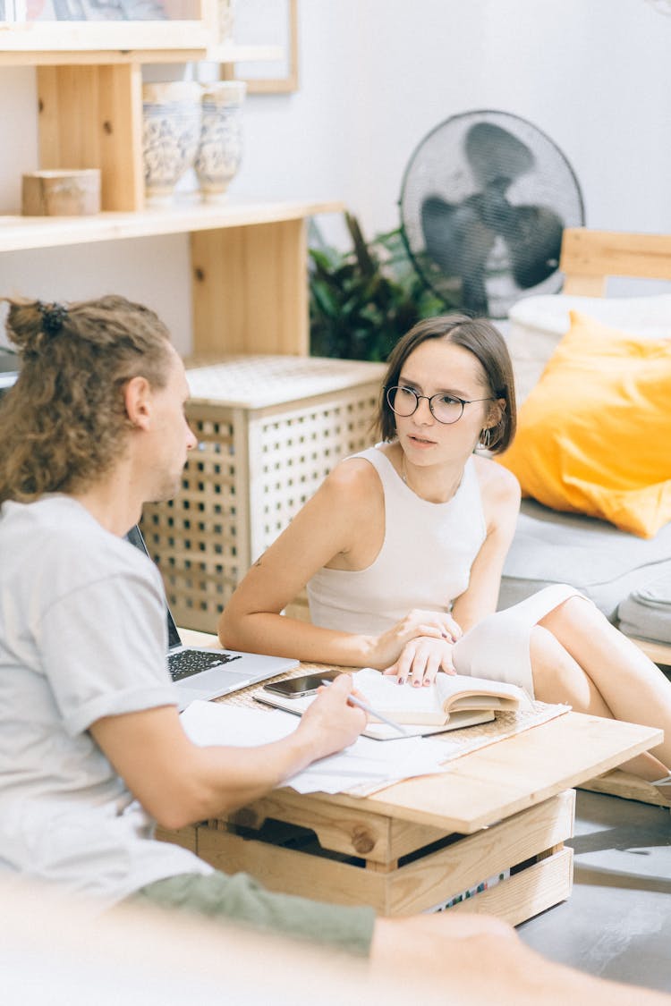 Man And A Woman Talking While Sitting On The Floor