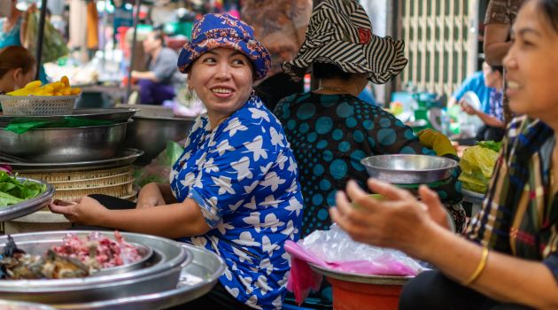 Women selling fresh produce at a vibrant street market in Ho Chi Minh City, Vietnam.