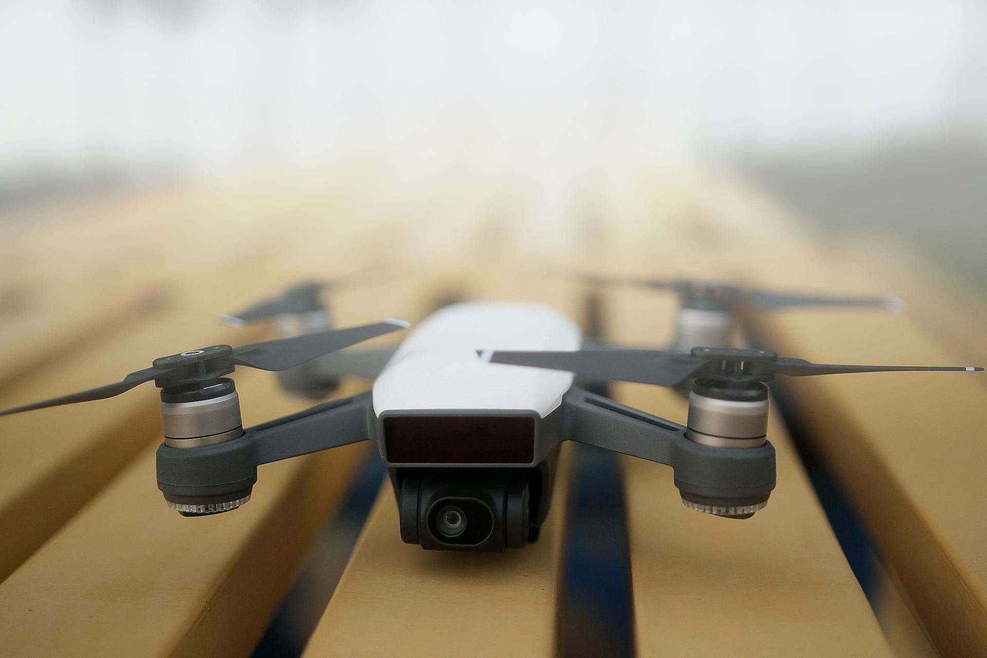 Captivating close-up of a sleek white drone resting on a wooden surface, perfect for technology enthusiasts.