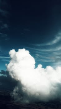 Aerial view of skyline with fluffy white clouds in bright blue sky over ground