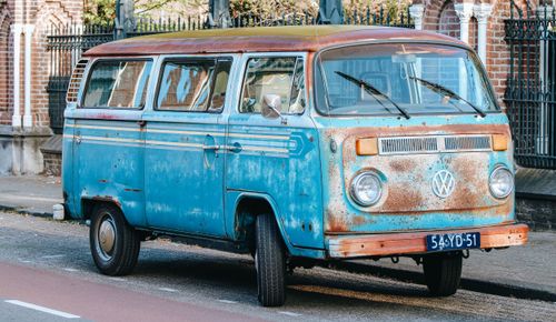 Free Rusty classic blue VW van parked on a city street, capturing a retro vibe. Stock Photo