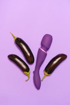 Playful composition of a purple vibrator with eggplants on a vibrant purple background.