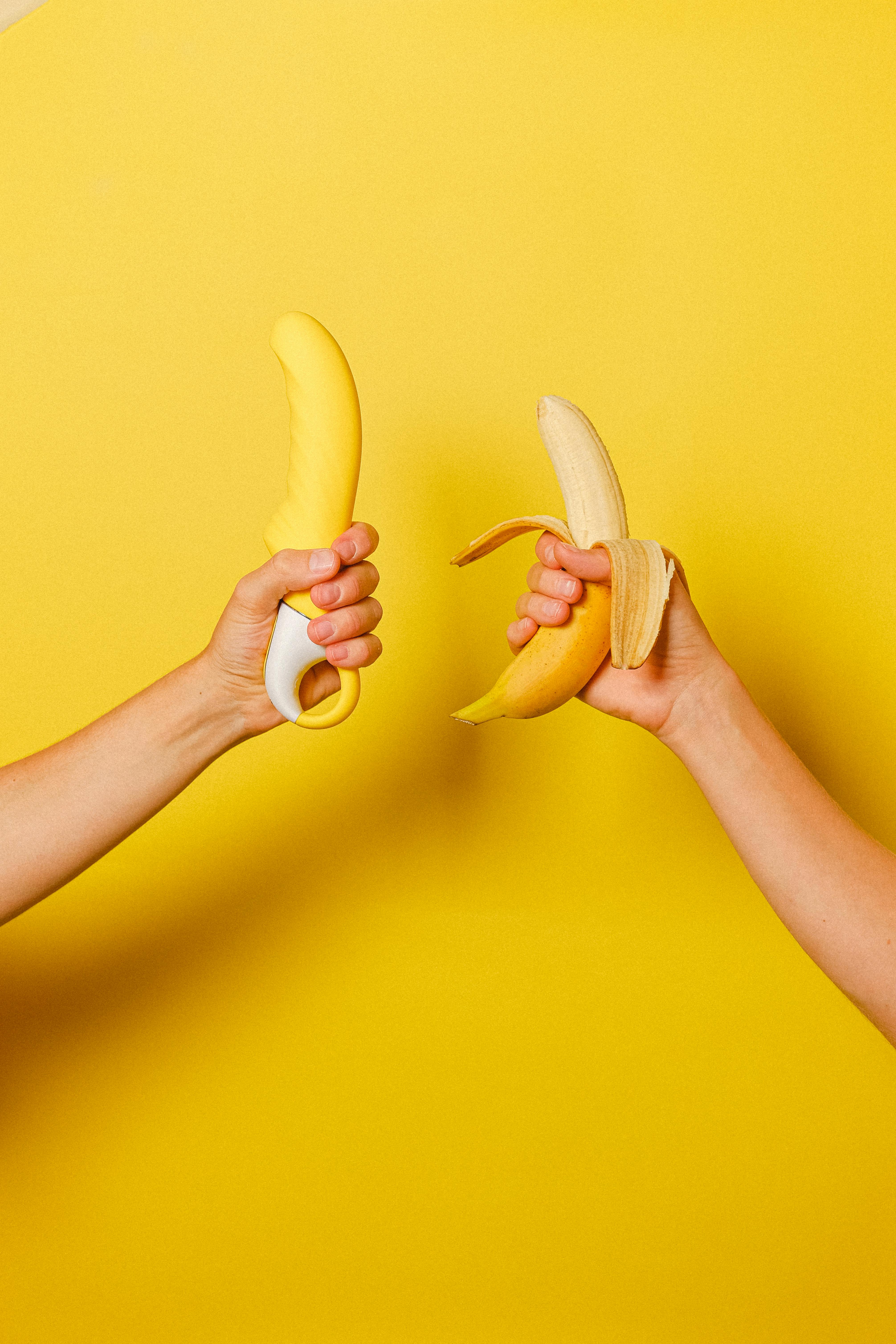 hands holding a banana and a sex toy