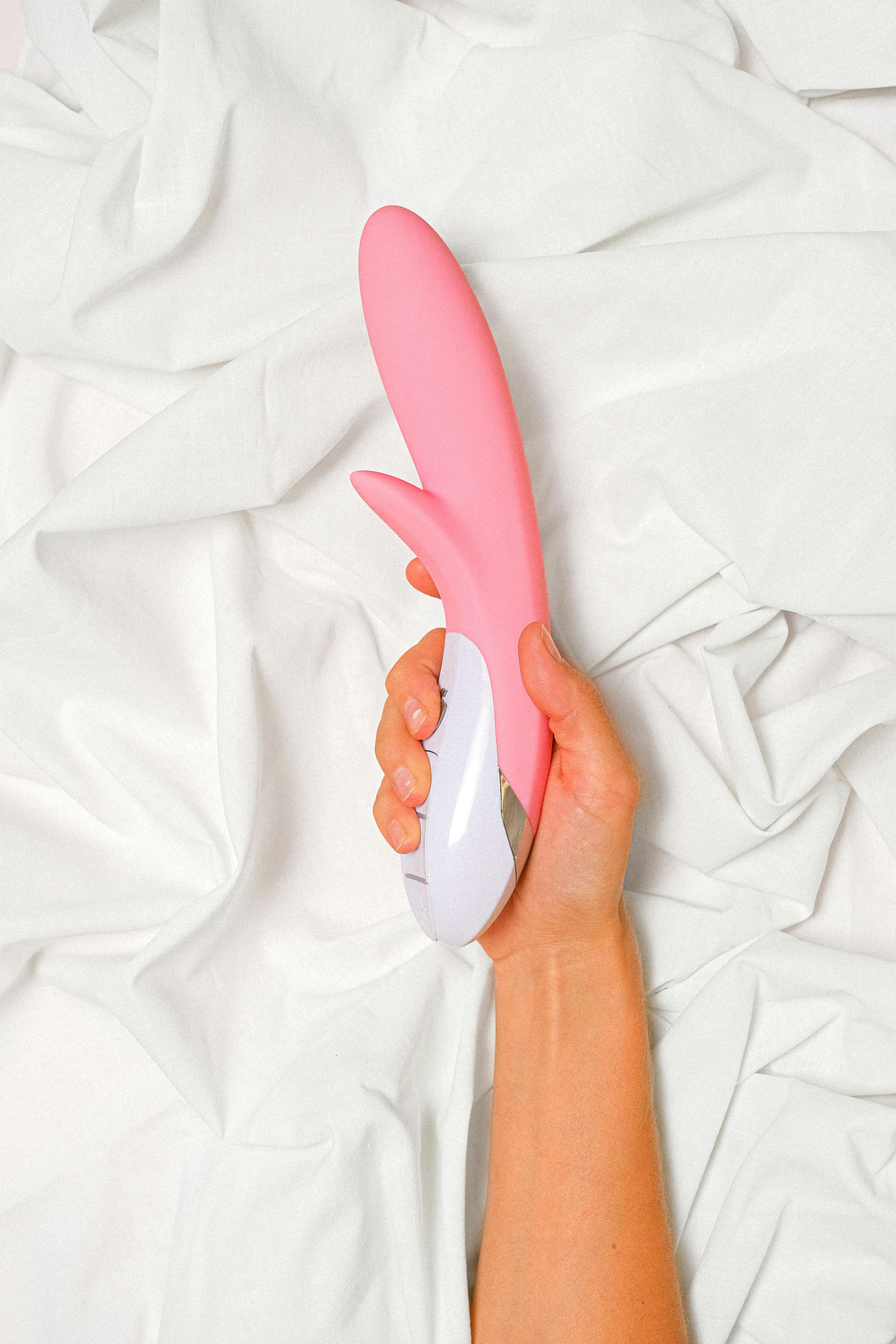 person holding a pink vibrator