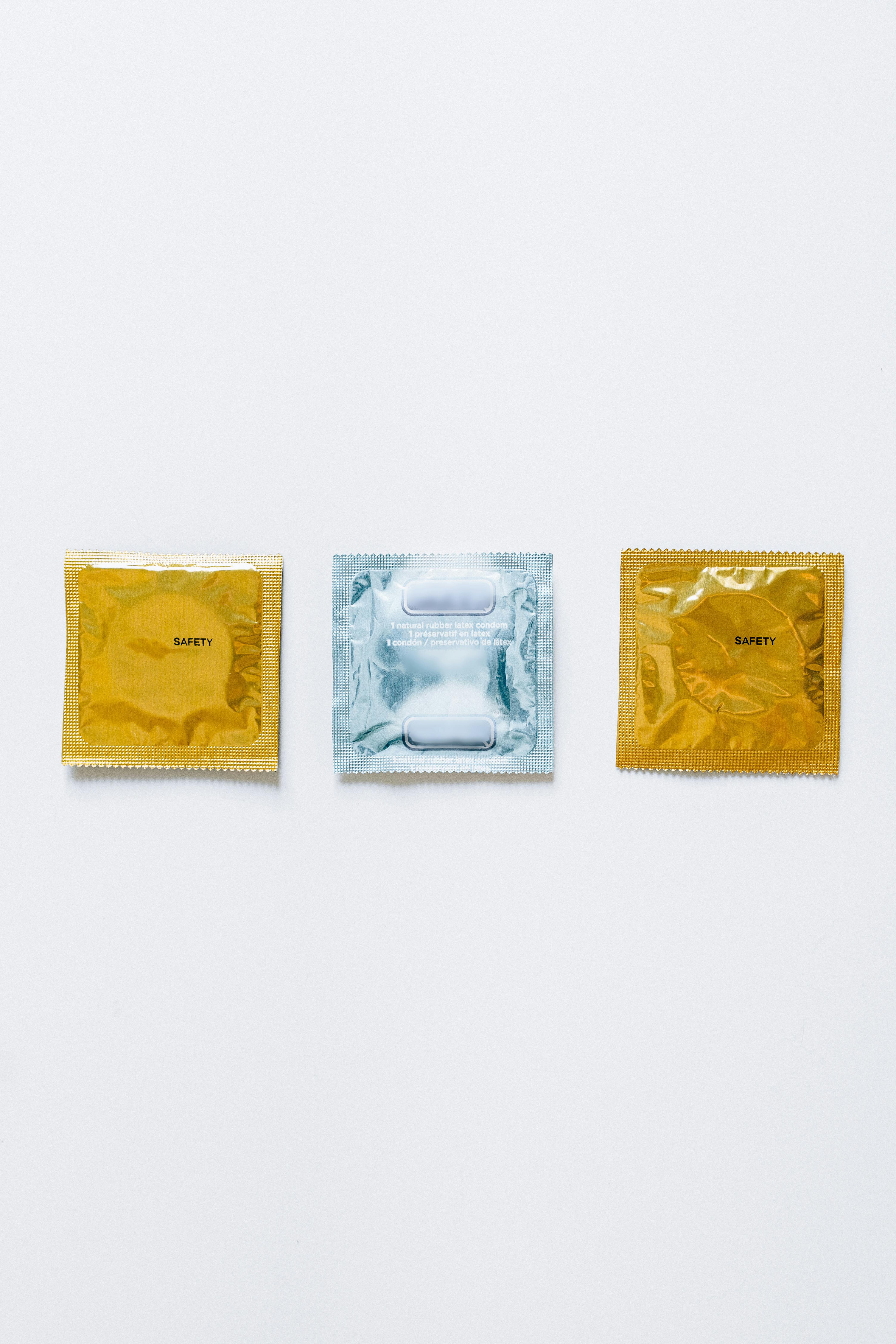 three condoms on white surface