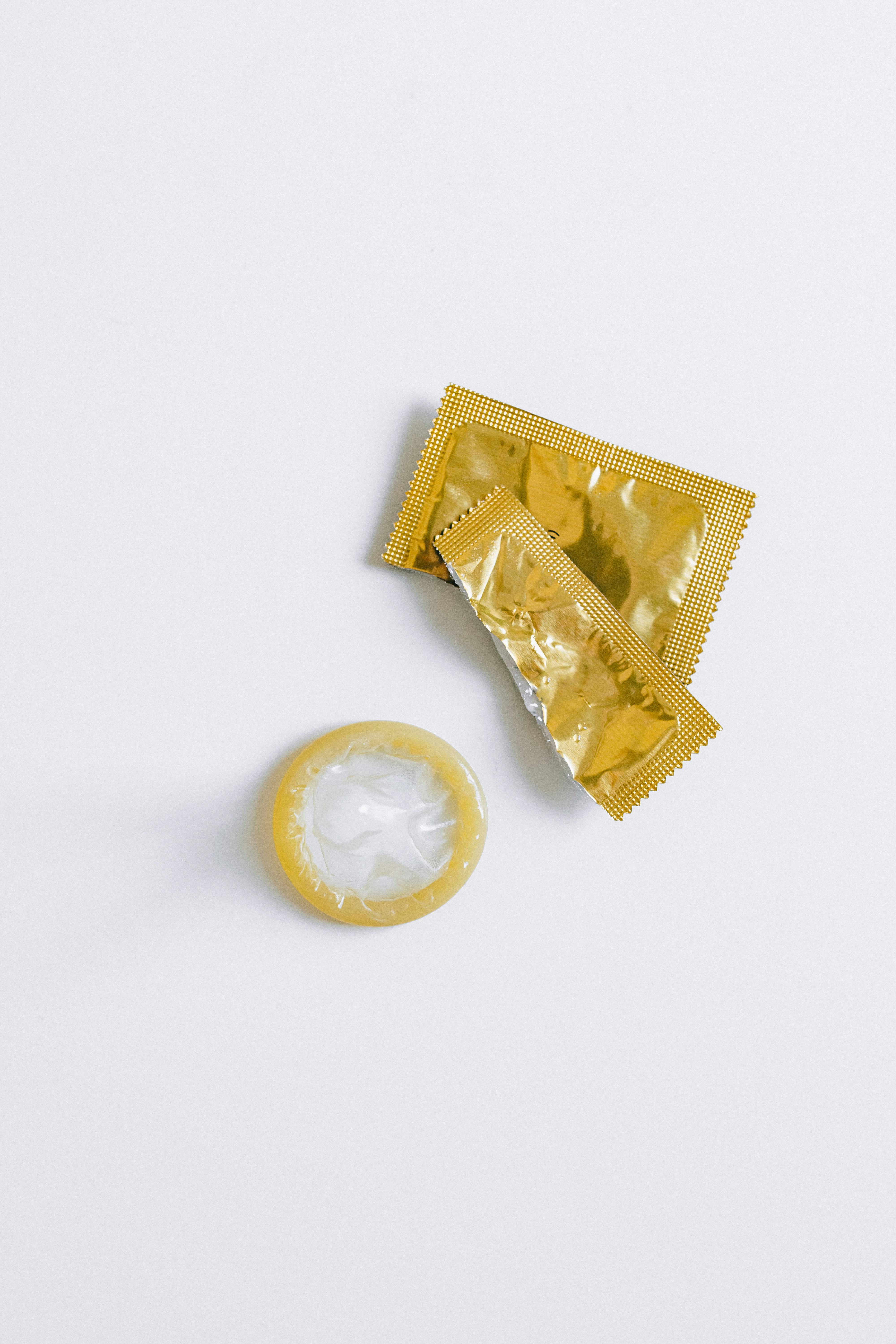 unwrapped condom on white surface