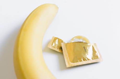 Unwrapped Condom Next to Banana