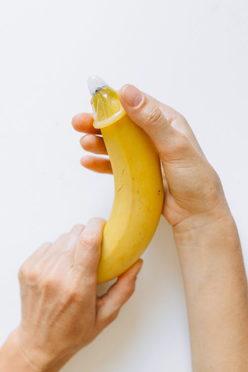 免費 在香蕉上包裹避孕套的人 圖庫相片